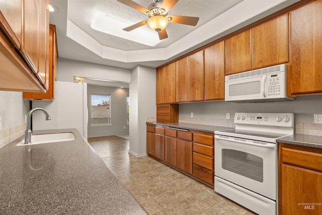 3017 Cypress St, Lewiston, ID 83501 - kitchen with white appliances, a sink, brown cabinetry, dark countertops, and ceiling fan