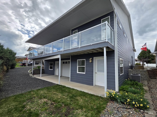 3017 Cypress St, Lewiston, ID 83501 - rear view of house with a balcony, central air condition unit, a patio, a garage, and asphalt driveway