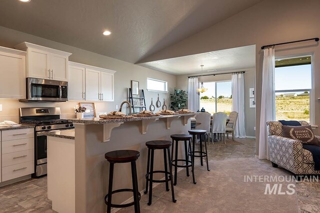 3808 N Anselmo Way Lot 18Block 16, Star, ID 83669 - kitchen with stainless steel appliances, vaulted ceiling, white cabinets, an island with sink, and a breakfast bar