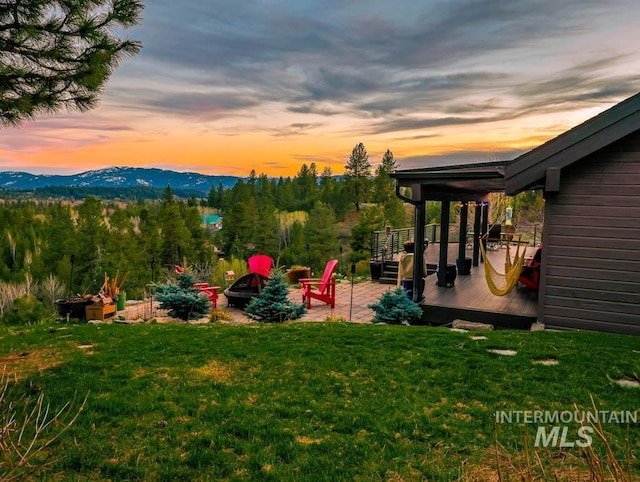 986 Valley Rim Rd, Mccall, ID 83638 - view of grassy yard with a fire pit, a deck with mountain view, and a patio