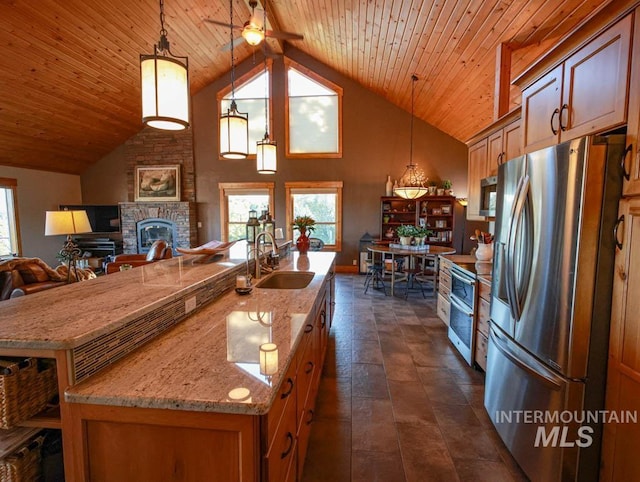 986 Valley Rim Rd, Mccall, ID 83638 - kitchen with stainless steel appliances, a sink, a fireplace, wood ceiling, and open floor plan
