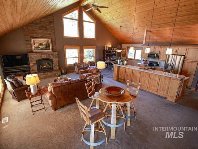 986 Valley Rim Rd, Mccall, ID 83638 - living area featuring dark carpet, wood ceiling, a ceiling fan, a fireplace, and high vaulted ceiling