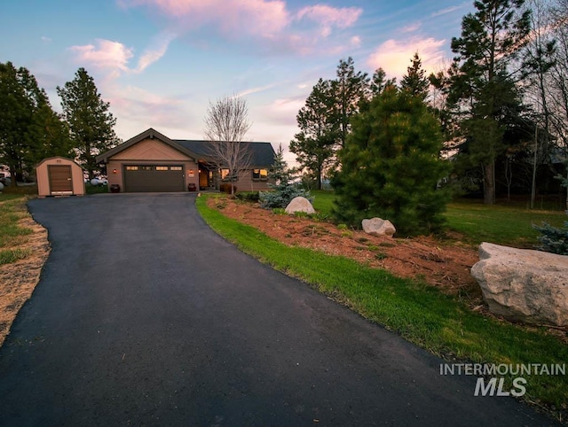 986 Valley Rim Rd, Mccall, ID 83638 - view of front of house with a garage, asphalt driveway, and an outbuilding