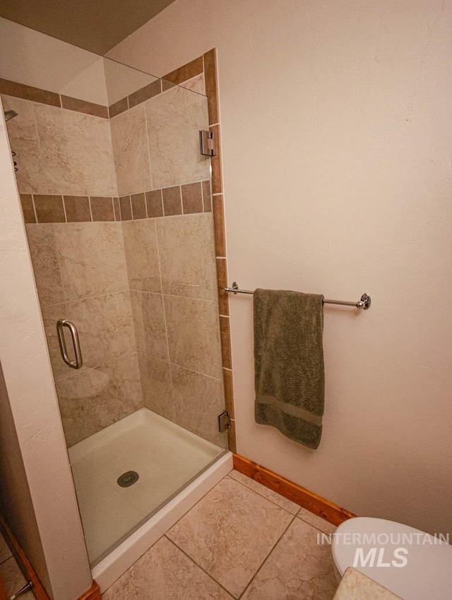 986 Valley Rim Rd, Mccall, ID 83638 - full bath with a stall shower, tile patterned floors, toilet, and baseboards