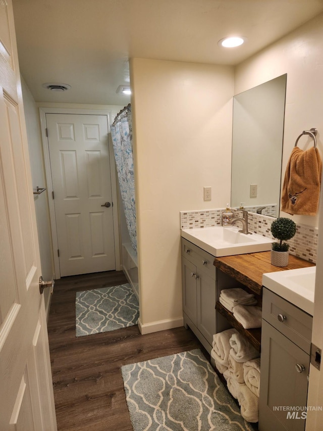 232 Camas Rd, Grangeville, ID 83530 - full bathroom featuring vanity, wood finished floors, tasteful backsplash, baseboards, and shower / bathtub combination with curtain