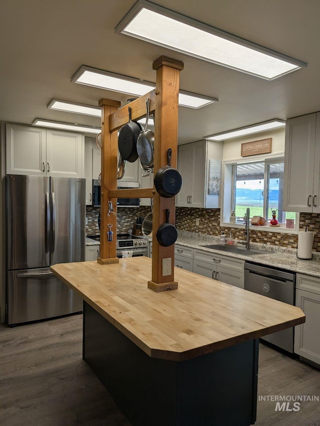 232 Camas Rd, Grangeville, ID 83530 - kitchen featuring butcher block countertops, stainless steel appliances, a sink, tasteful backsplash, and dark wood-type flooring