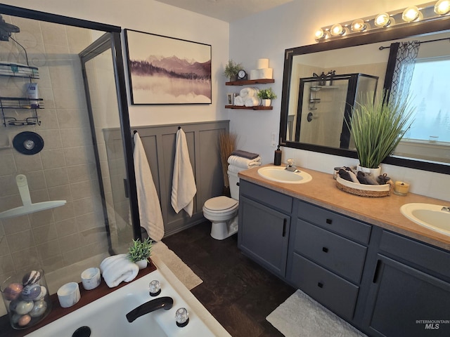 full bathroom with a sink, double vanity, a shower stall, and toilet