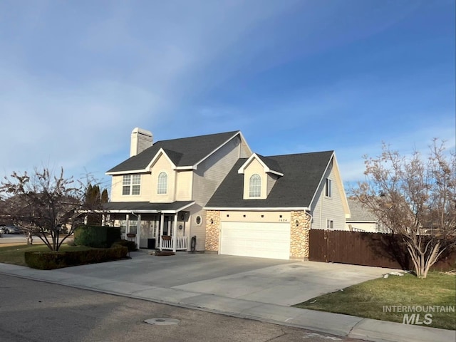 view of front of home with driveway, a chimney, an attached garage, covered porch, and fence