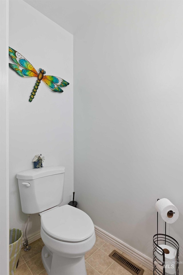 bathroom featuring baseboards, toilet, and tile patterned flooring