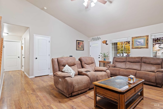 living room featuring ceiling fan, high vaulted ceiling, light wood-style flooring, and baseboards