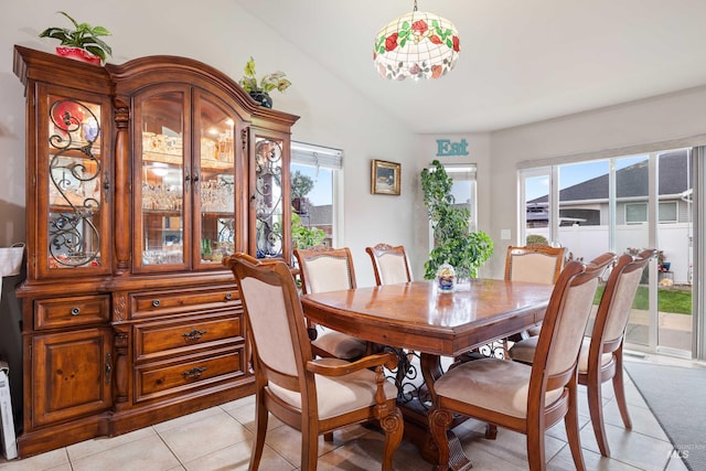 dining area with light tile patterned floors and lofted ceiling