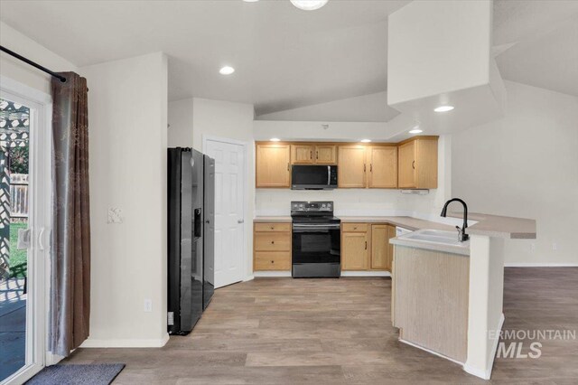 555 W Mulberry Loop, Nampa, ID 83686 - kitchen featuring black appliances, light brown cabinets, lofted ceiling, a peninsula, and light wood-type flooring