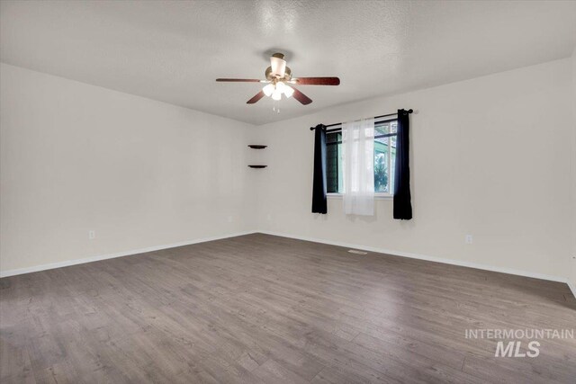 555 W Mulberry Loop, Nampa, ID 83686 - empty room with a ceiling fan, dark wood-style floors, and a textured ceiling