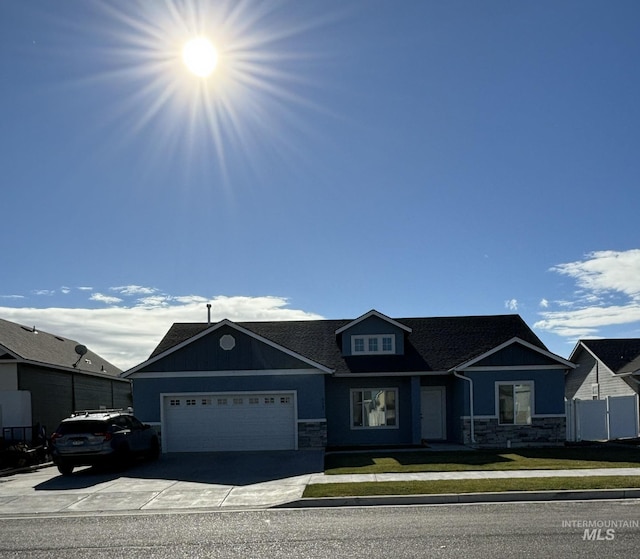 view of front facade featuring a garage, stone siding, and driveway