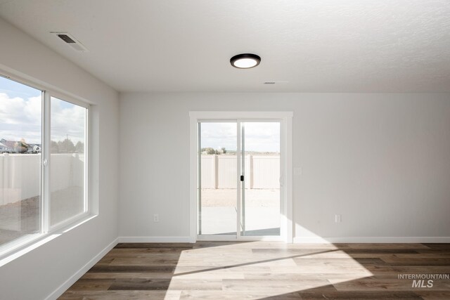 11075 W Windmill Way, Nampa, ID 83651 - empty room with plenty of natural light, dark wood-type flooring, visible vents, and baseboards