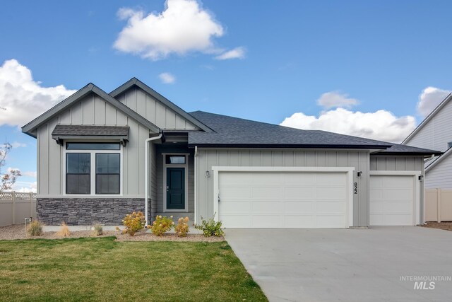 view of front of home with an attached garage, driveway, board and batten siding, and fence