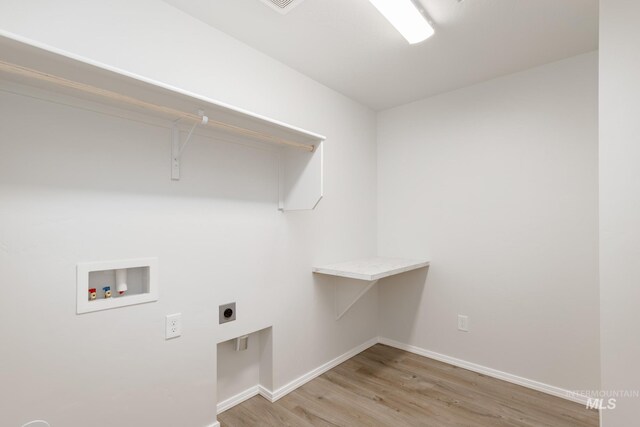 clothes washing area featuring baseboards, light wood-type flooring, laundry area, hookup for a washing machine, and hookup for an electric dryer