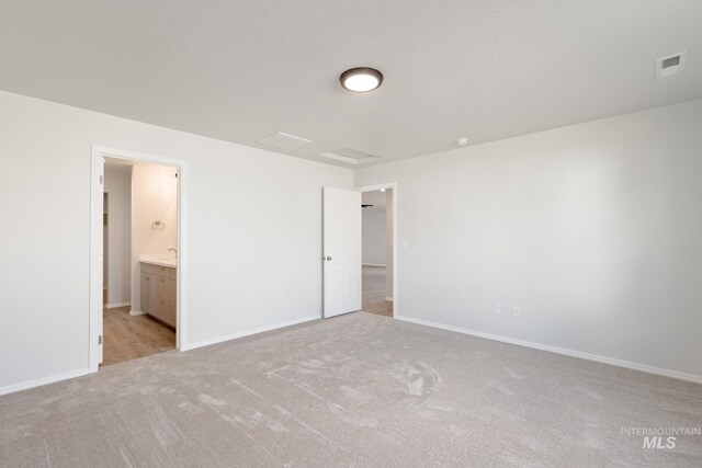 unfurnished bedroom featuring visible vents, baseboards, and light colored carpet