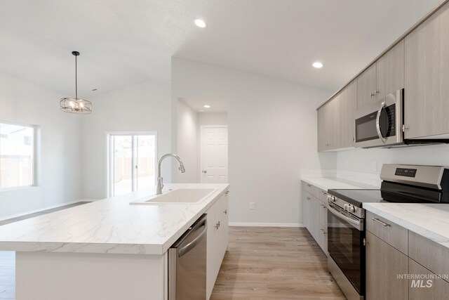 kitchen featuring light wood-style flooring, recessed lighting, a sink, vaulted ceiling, and appliances with stainless steel finishes