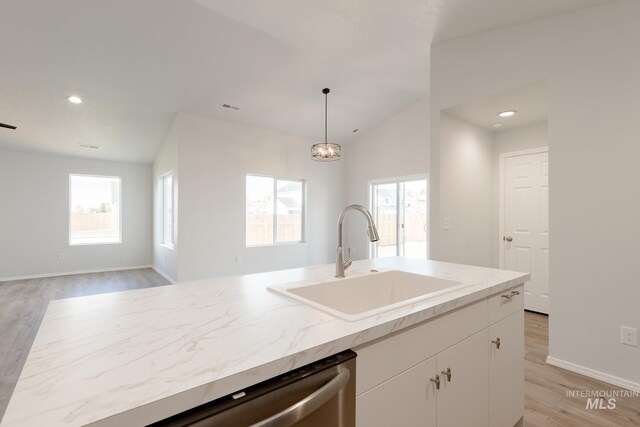 kitchen with a sink, light wood-style floors, a healthy amount of sunlight, and white cabinets