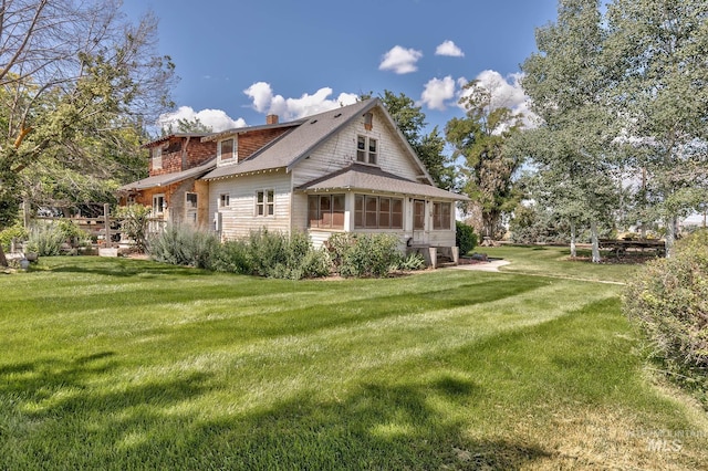1507 Scheloske Rd, Weiser, ID 83672 - view of home's exterior with a sunroom, a yard, a chimney, and a shingled roof