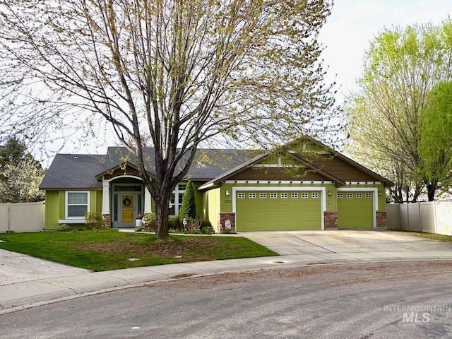 view of front of house with a front yard, an attached garage, fence, and driveway