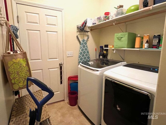 laundry room featuring light tile patterned floors, separate washer and dryer, and laundry area