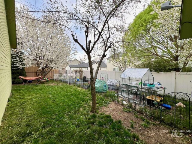 view of yard with a fenced backyard, an exterior structure, and an outdoor structure
