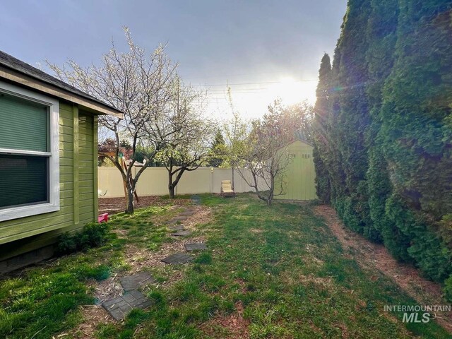 view of yard with an outbuilding, fence, and a storage unit