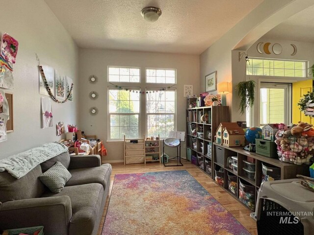 living area with a textured ceiling and wood finished floors