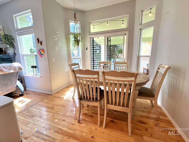 dining room featuring light wood finished floors and baseboards
