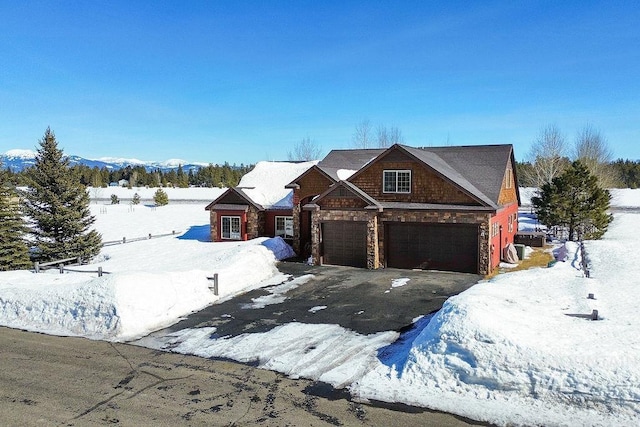 view of front of home featuring a garage, stone siding, and aphalt driveway