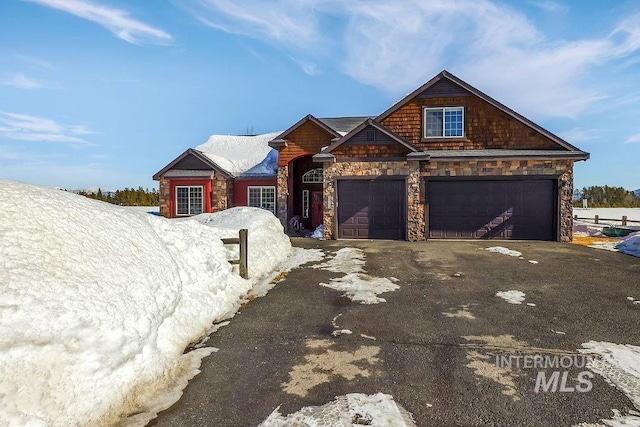 view of front of property with a garage, driveway, and stone siding