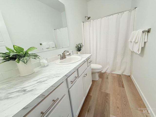 full bathroom with toilet, vanity, wood finished floors, a shower with curtain, and baseboards