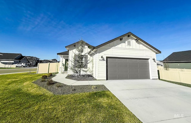 view of front of property with board and batten siding, fence, a garage, driveway, and a front lawn