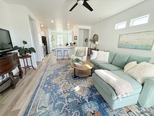 living area with light wood finished floors, ceiling fan, and recessed lighting