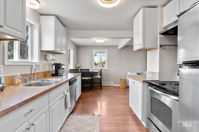 13771/2 Poplar, Clarkston, WA 99403 - kitchen featuring appliances with stainless steel finishes, a sink, light wood-type flooring, and white cabinetry