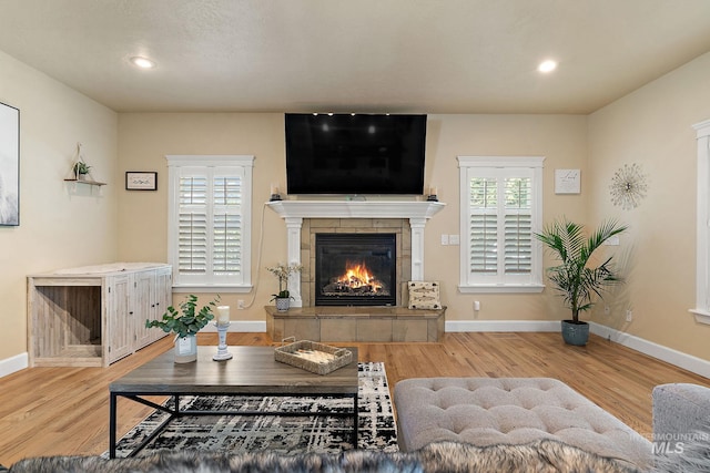 6114 N Cape Arago Pl, Boise, ID 83714 - living room featuring wood finished floors, a tiled fireplace, baseboards, and recessed lighting