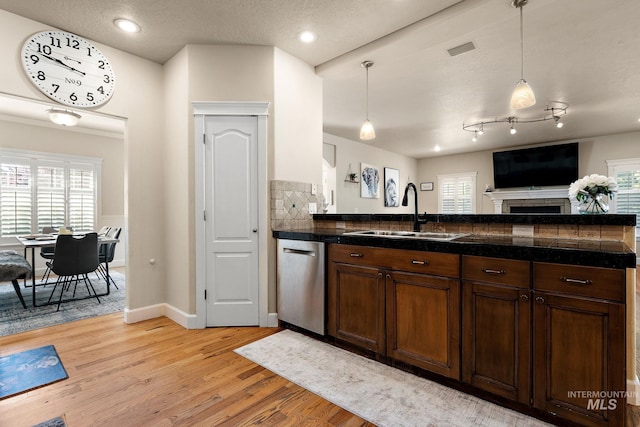 6114 N Cape Arago Pl, Boise, ID 83714 - kitchen featuring tile counters, a sink, stainless steel dishwasher, light wood-type flooring, and decorative light fixtures