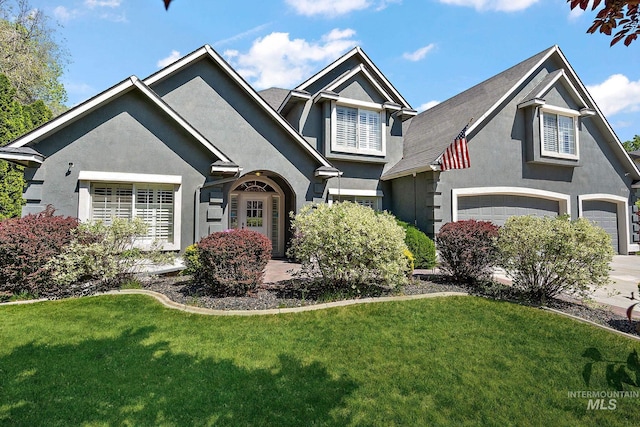6114 N Cape Arago Pl, Boise, ID 83714 - view of front of house with stucco siding, a front yard, concrete driveway, and a garage