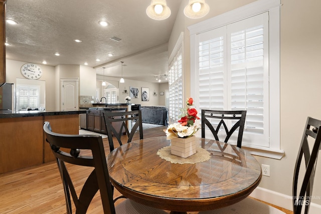 6114 N Cape Arago Pl, Boise, ID 83714 - dining room with plenty of natural light, baseboards, recessed lighting, light wood finished floors, and a textured ceiling