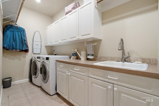 6114 N Cape Arago Pl, Boise, ID 83714 - laundry room featuring washing machine and dryer, cabinet space, light tile patterned flooring, and baseboards