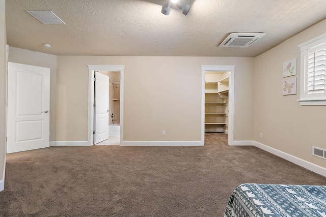 6114 N Cape Arago Pl, Boise, ID 83714 - unfurnished bedroom featuring a walk in closet, carpet, a textured ceiling, and baseboards
