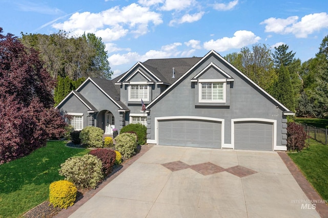 6114 N Cape Arago Pl, Boise, ID 83714 - view of front of home with stucco siding, driveway, an attached garage, and a front lawn