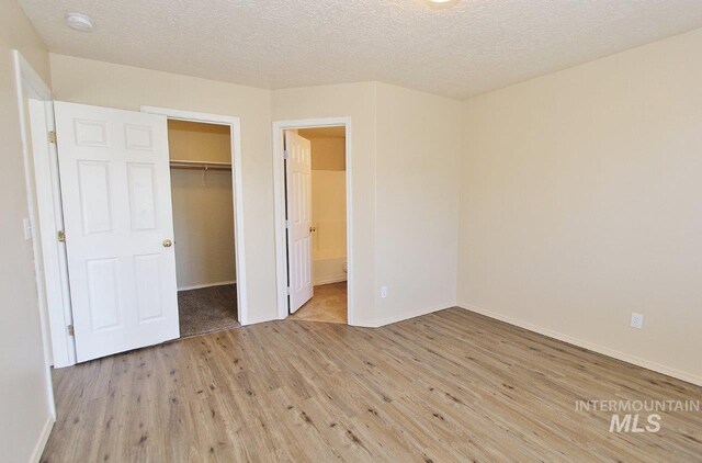 unfurnished bedroom with baseboards, a closet, and wood finished floors