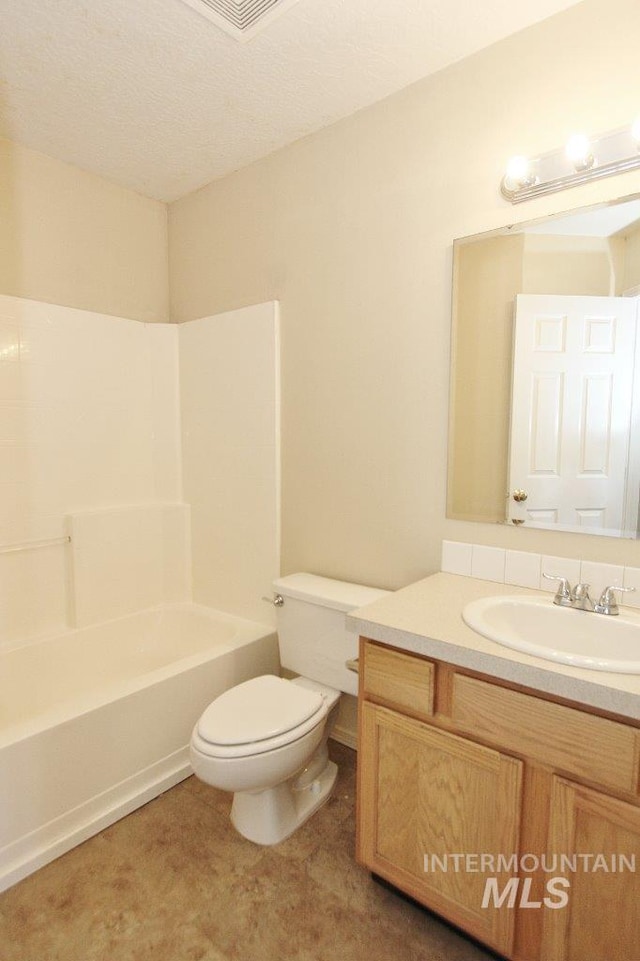 bathroom with vanity, a textured ceiling, toilet, and shower / tub combination