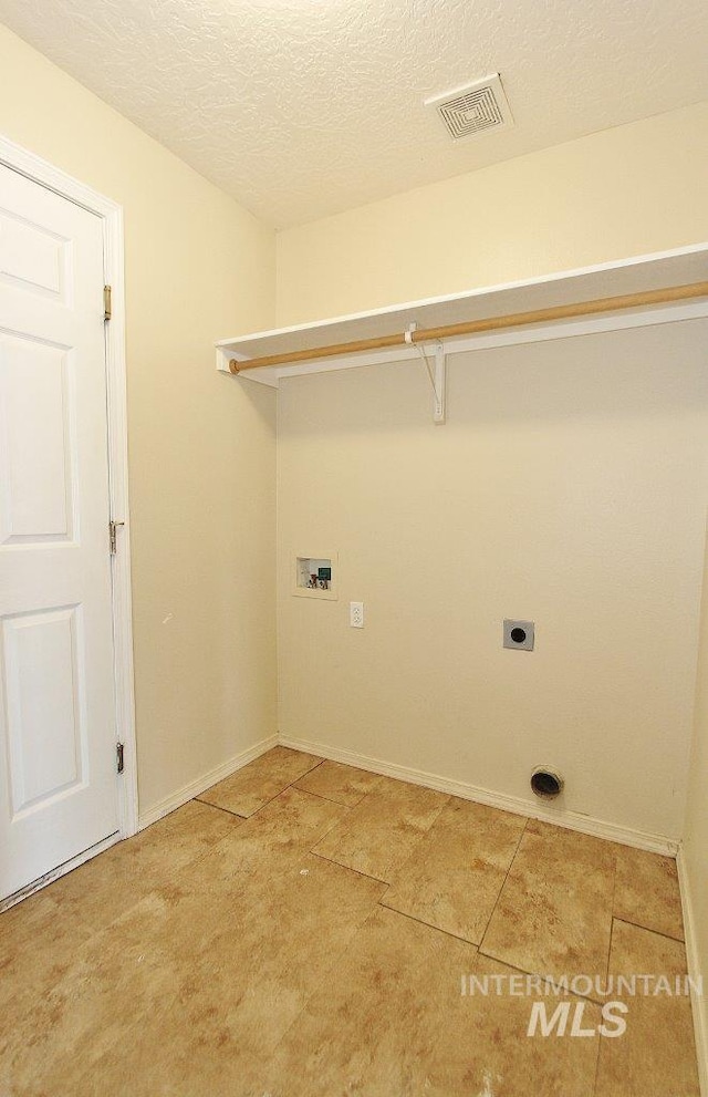 laundry area featuring washer hookup, laundry area, a textured ceiling, visible vents, and baseboards
