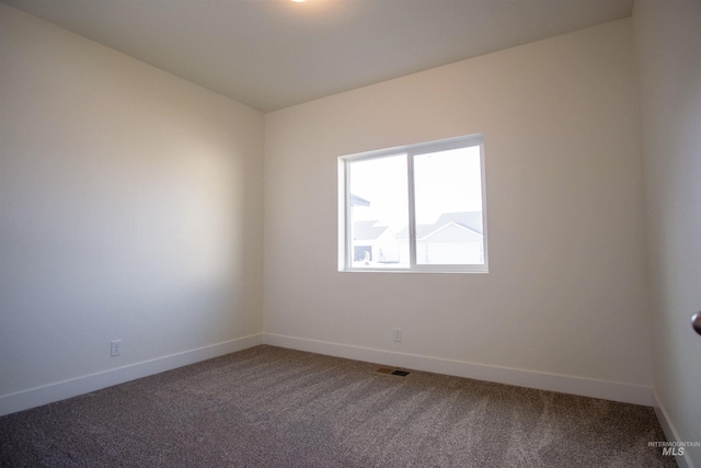 spare room with dark colored carpet