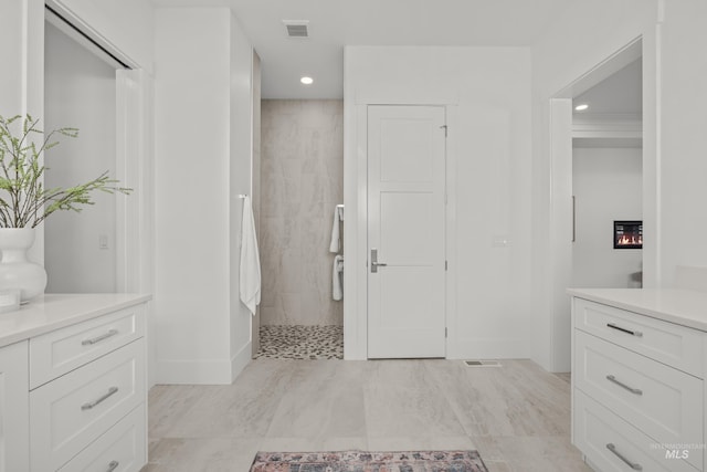 bathroom featuring a tile shower and vanity