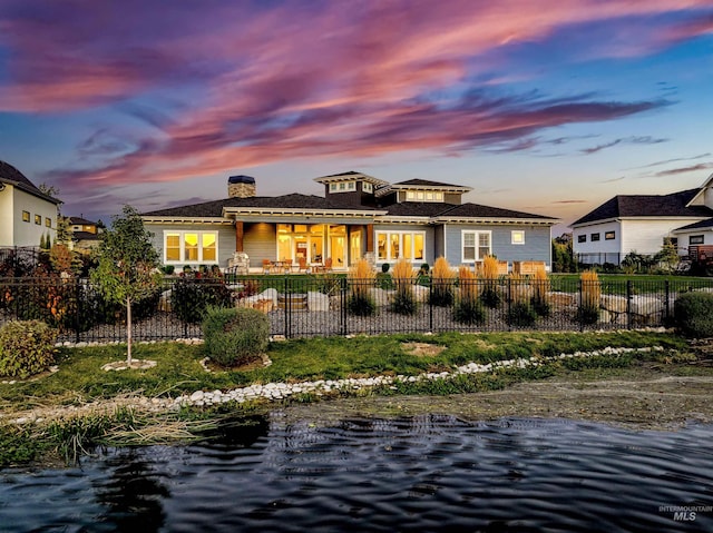 back house at dusk with a water view